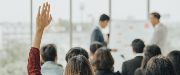 Professional raises their hand in a classroom.